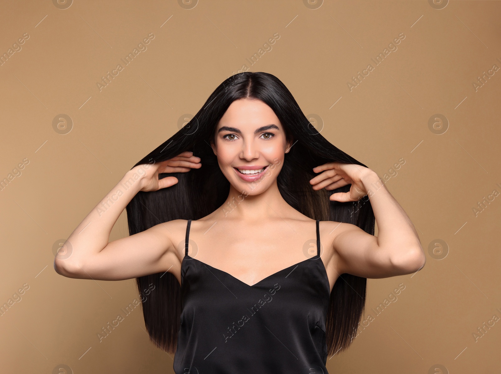 Photo of Portrait of beautiful young woman with healthy strong hair on beige background