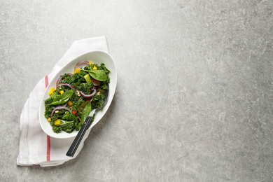 Photo of Tasty fresh kale salad on light grey table, top view