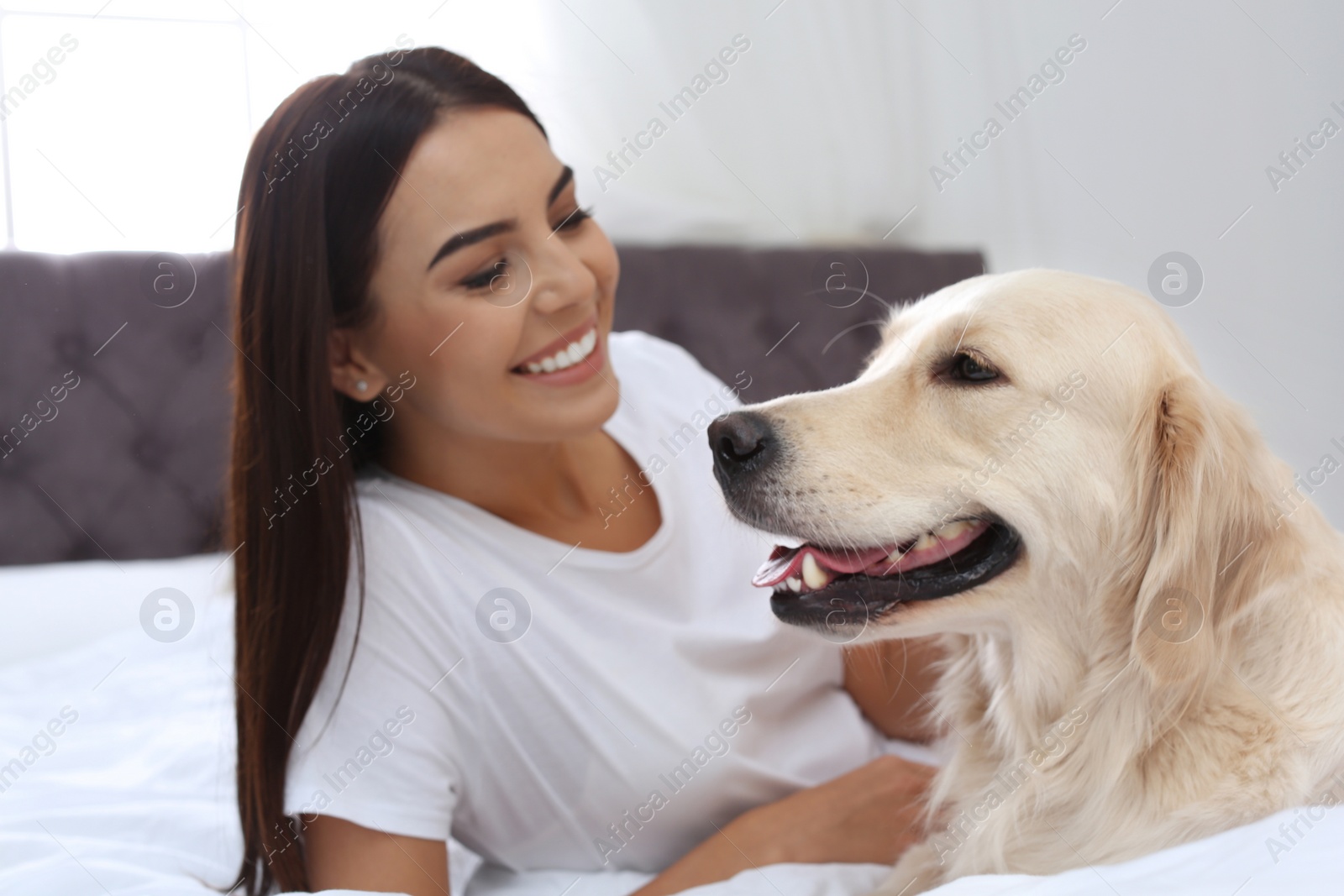 Image of Happy woman with her cute pet dog at home