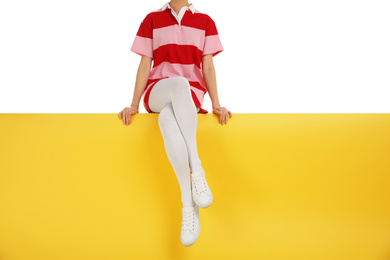 Woman wearing white tights and stylish shoes sitting on color background, closeup