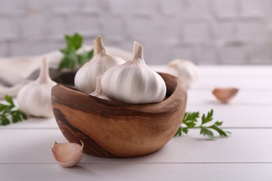 Photo of Fresh garlic on white wooden table, closeup. Space for text