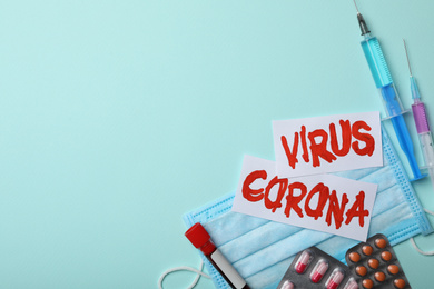 Photo of Flat lay composition with phrase CORONA VIRUS and medicines on light blue background. Space for text