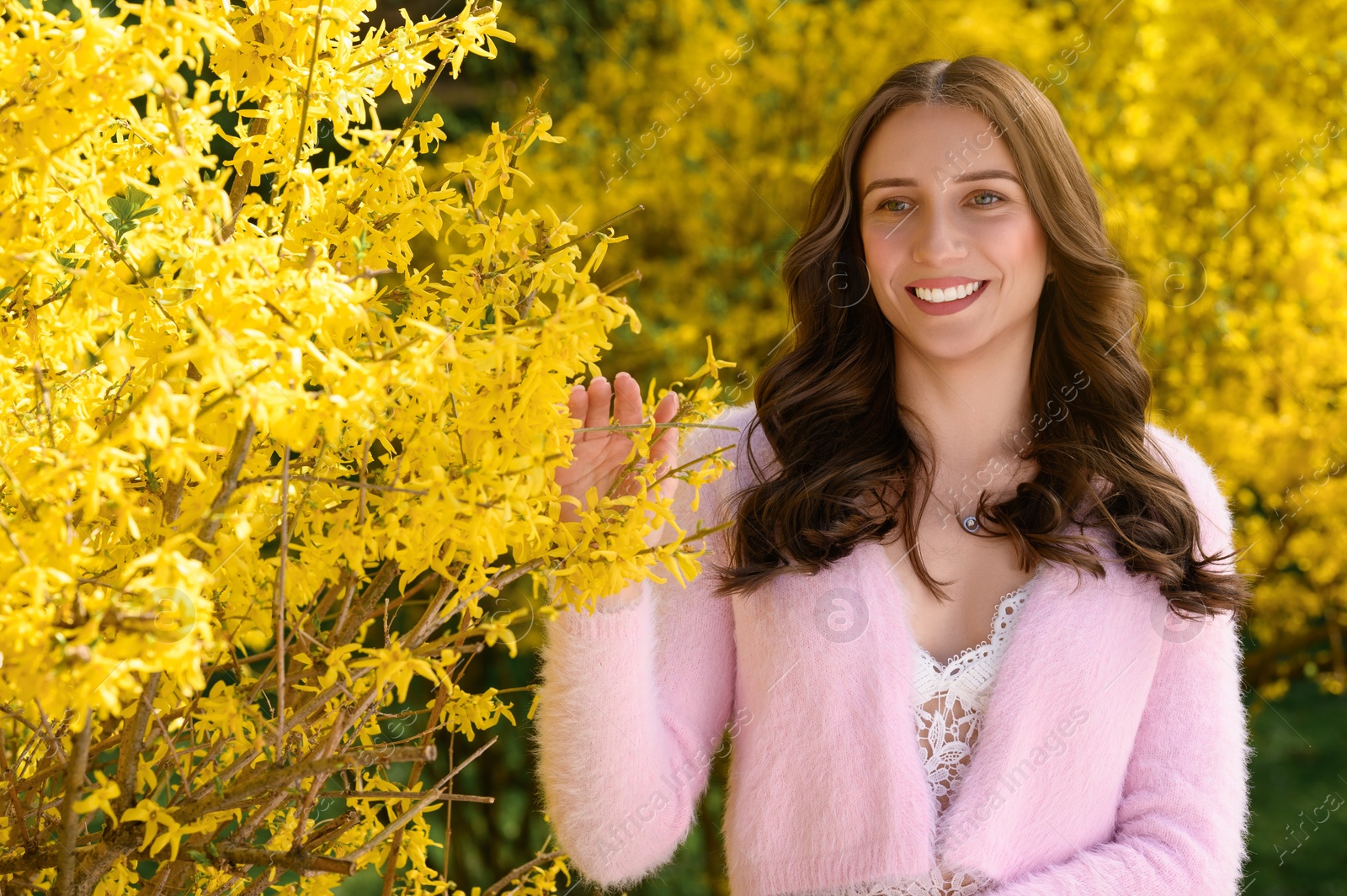 Photo of Beautiful young woman near blossoming shrub on spring day