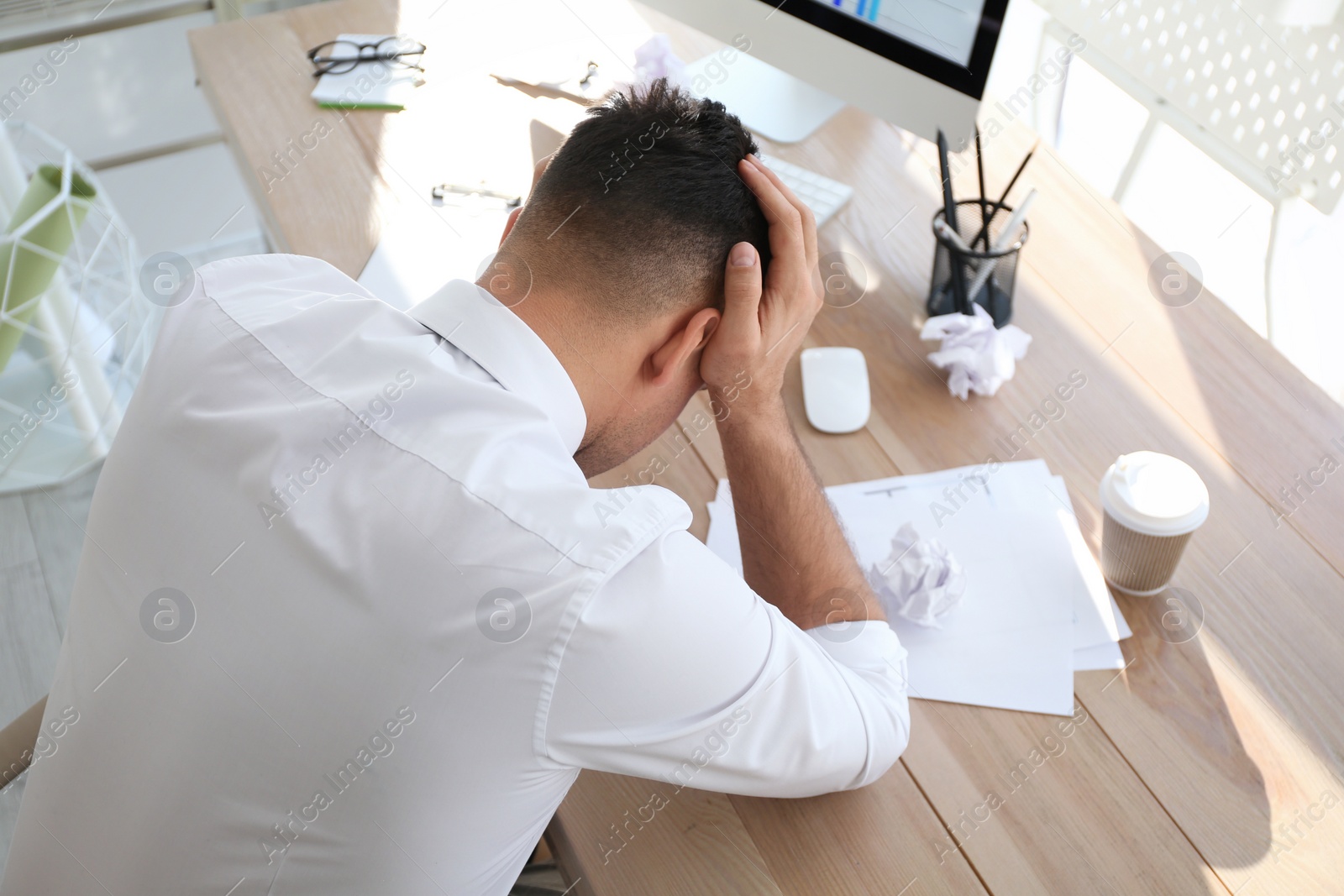 Photo of Businessman stressing out at workplace in office, above view