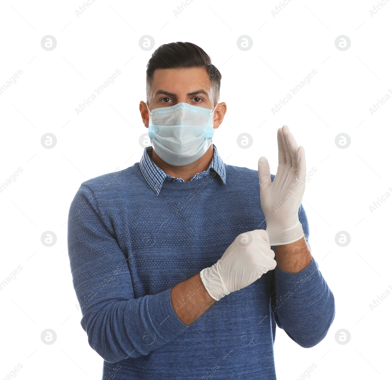 Photo of Man in protective face mask putting on medical gloves against white background