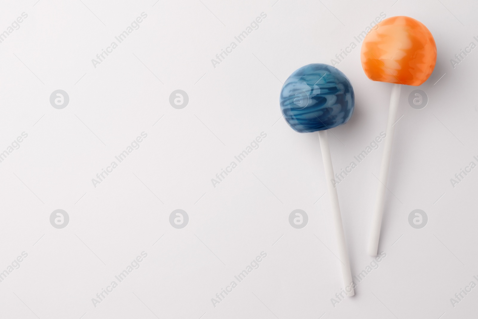 Photo of Tasty lollipops on white background, flat lay. Space for text