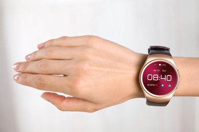 Image of Woman with smart watch displaying time, date and heart rate, closeup