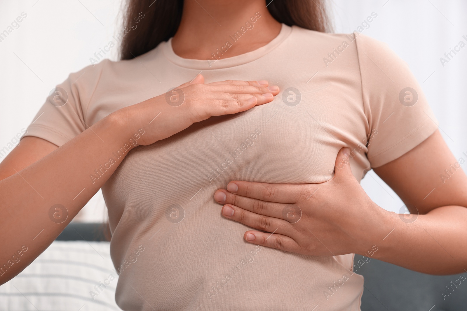 Photo of Woman doing breast self-examination at home, closeup