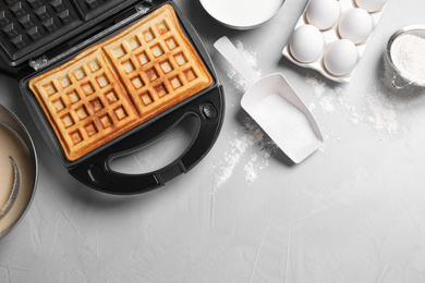 Flat lay composition with fresh Belgian waffles on light grey table