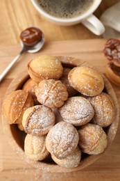 Bowl of delicious nut shaped cookies on wooden table, flat lay