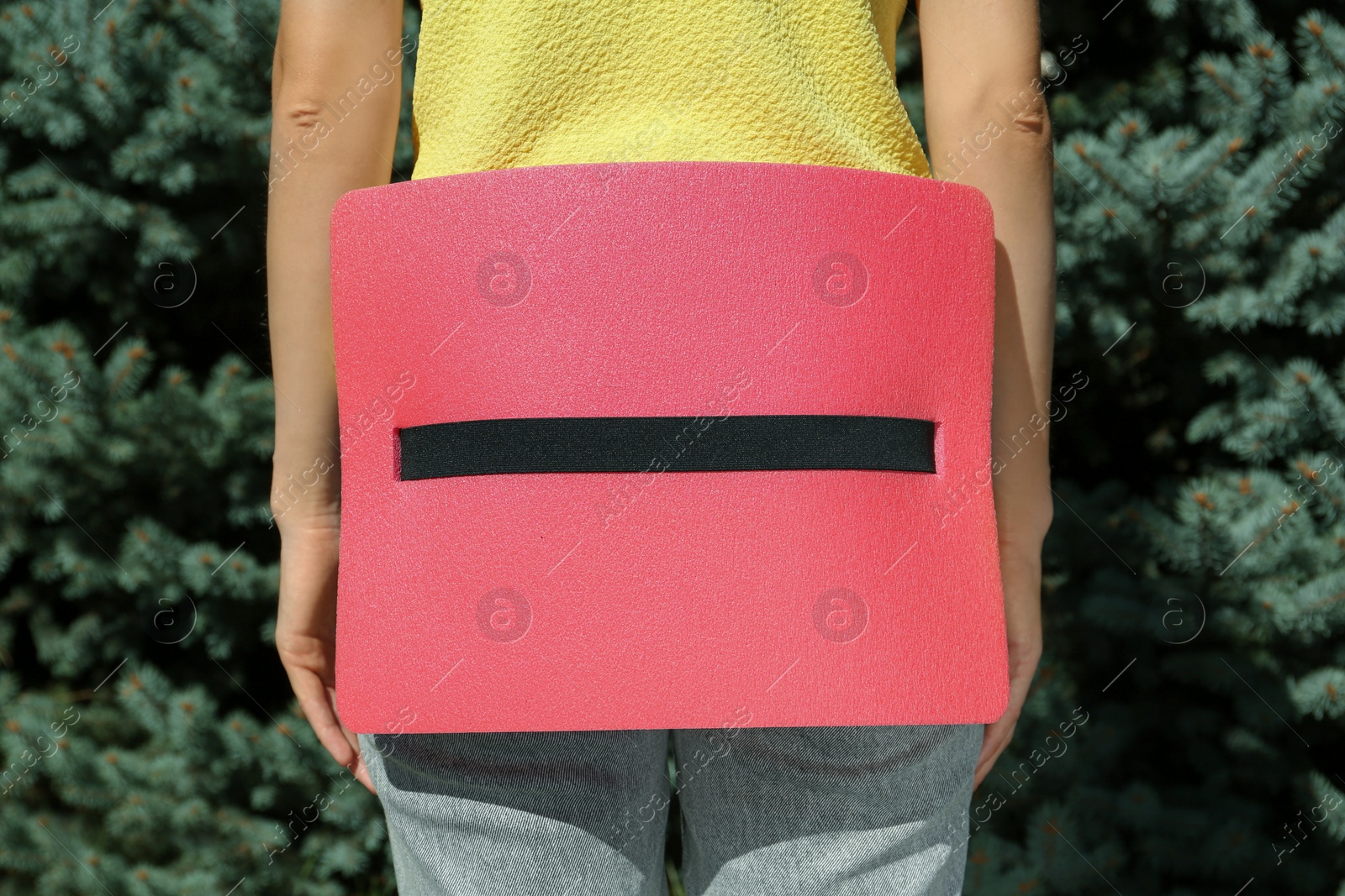 Photo of Woman with foam tourist seat mat outdoors, closeup