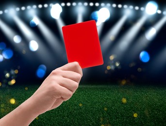 Image of Referee holding red card at stadium, closeup