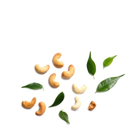 Photo of Tasty cashew nuts and leaves isolated on white, top view. Space for text