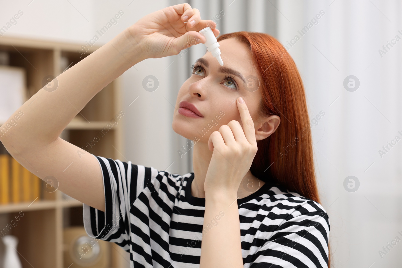 Photo of Woman applying medical eye drops at home