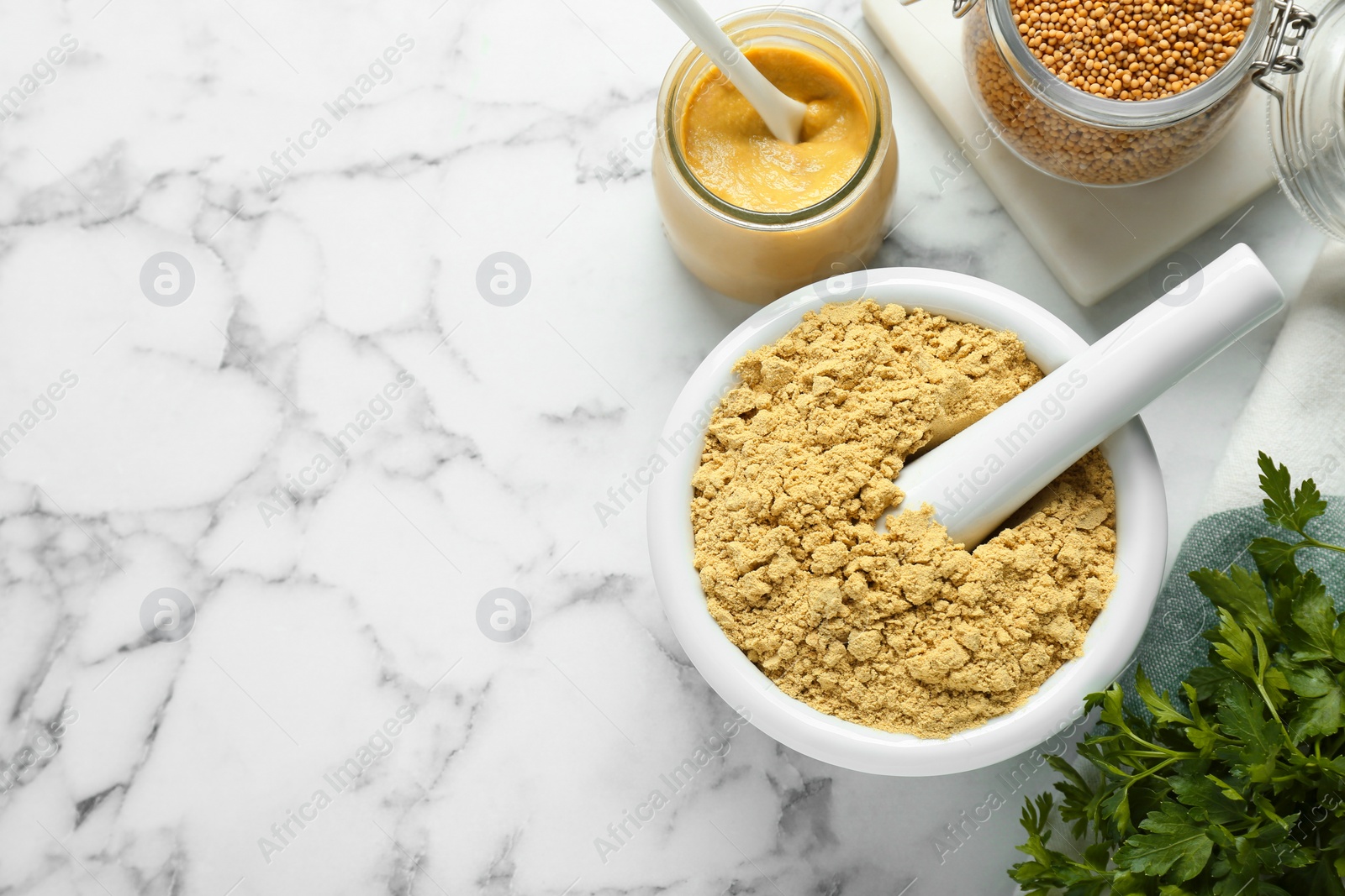 Photo of Flat lay composition with mortar and aromatic mustard powder on white marble table. Space for text