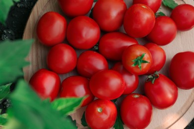 Photo of Wooden board with fresh ripe tomatoes, top view