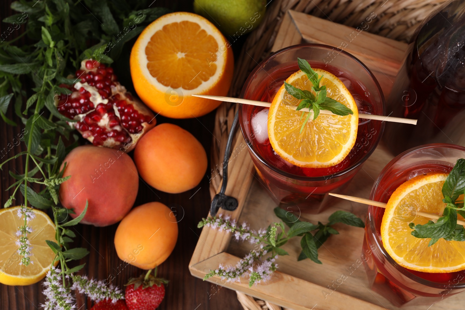 Photo of Delicious refreshing sangria, fresh fruits and berries on wooden table, above view