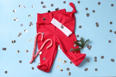 Photo of Flat lay composition with cute Christmas baby clothes on light blue background