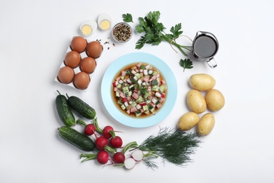 Photo of Cold okroshka with kvass and ingredients on white background, top view. Traditional Russian summer soup