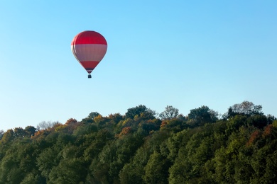 Photo of Beautiful view of hot air balloon flying over autumn forest. Space for text