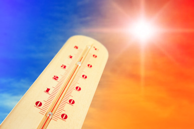 Image of Weather thermometer with high temperature and color sky on background, space for text 