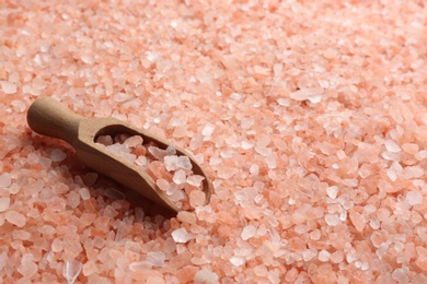 Pink himalayan salt and wooden scoop as background, closeup