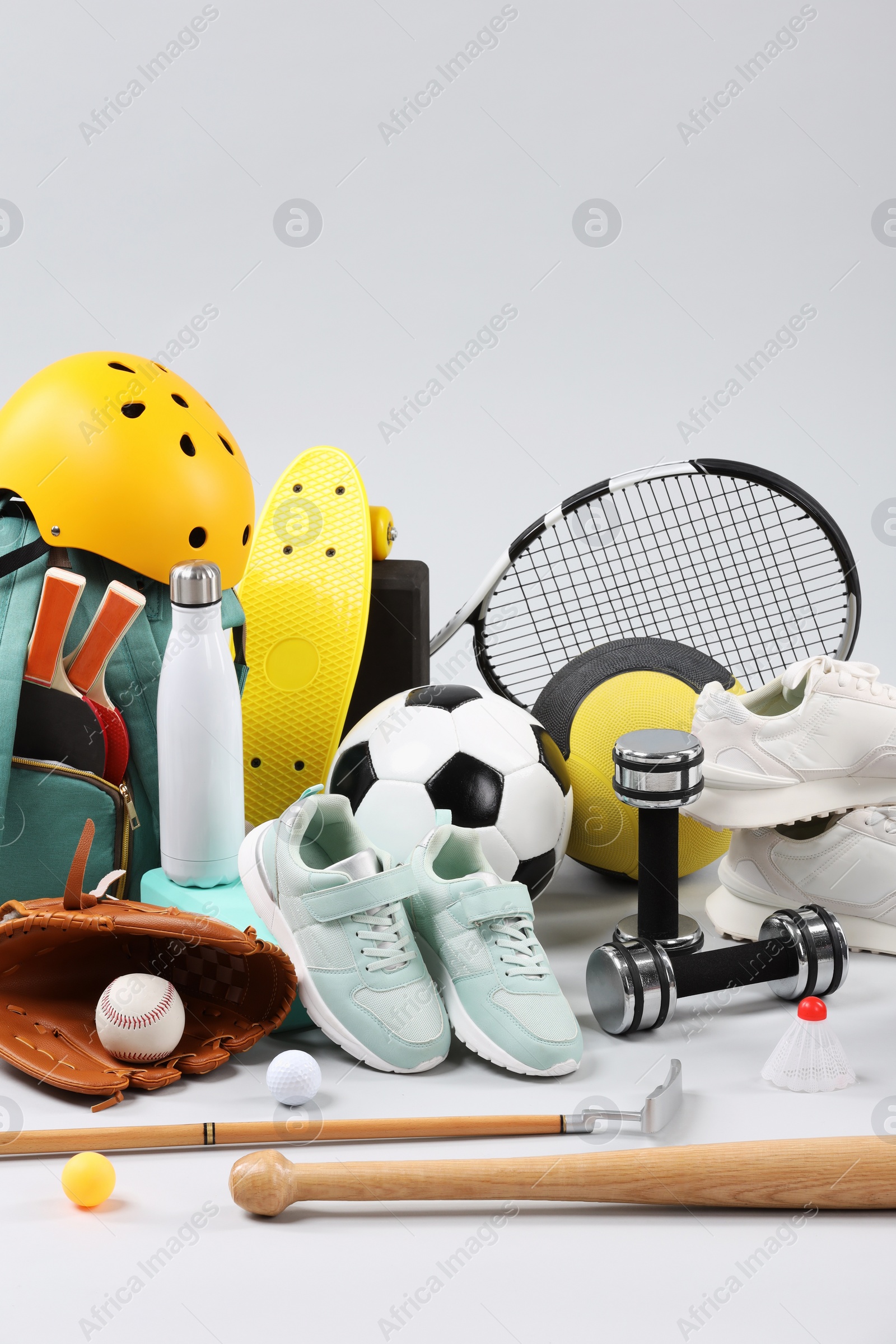 Photo of Many different sports equipment on light grey background