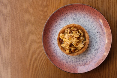 Photo of Plate with delicious cake on wooden table, top view