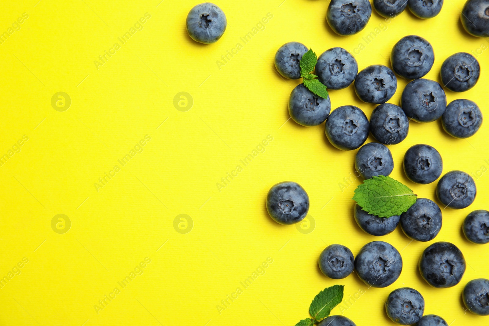 Photo of Flat lay composition with tasty blueberry and space for text on color background