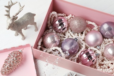 Photo of Composition with beautiful Christmas baubles on white wooden table, above view