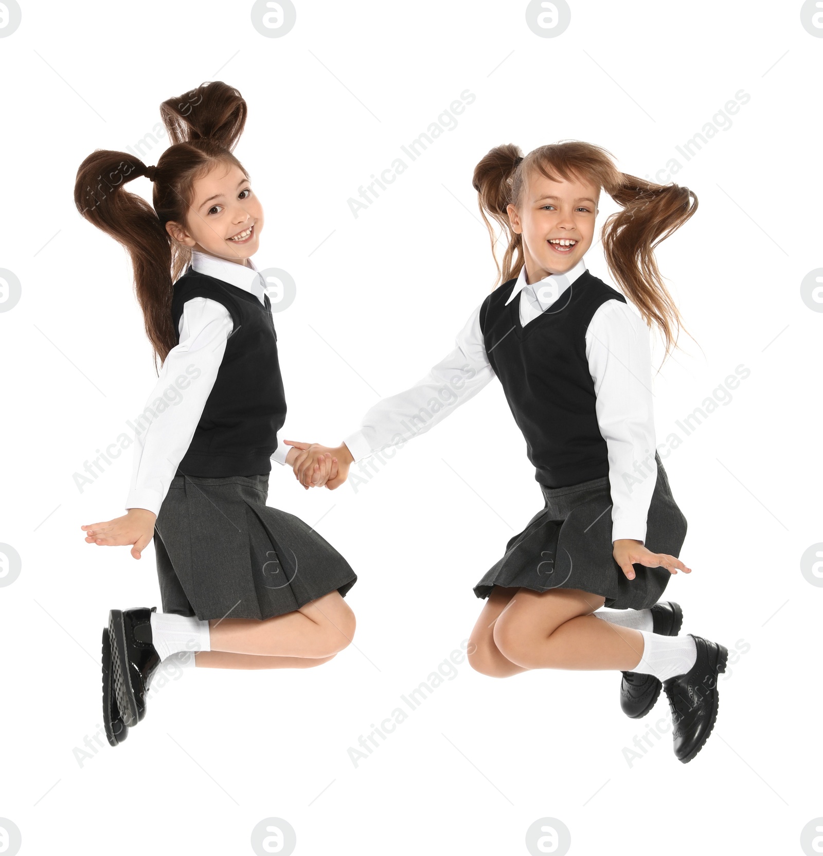 Photo of Little girls in stylish school uniform on white background