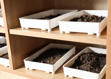 Photo of Containers with soil samples on shelves indoors. Laboratory research