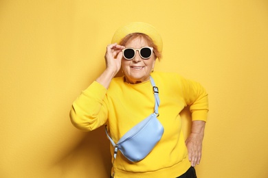 Photo of Portrait of elderly woman in hipster outfit on color background