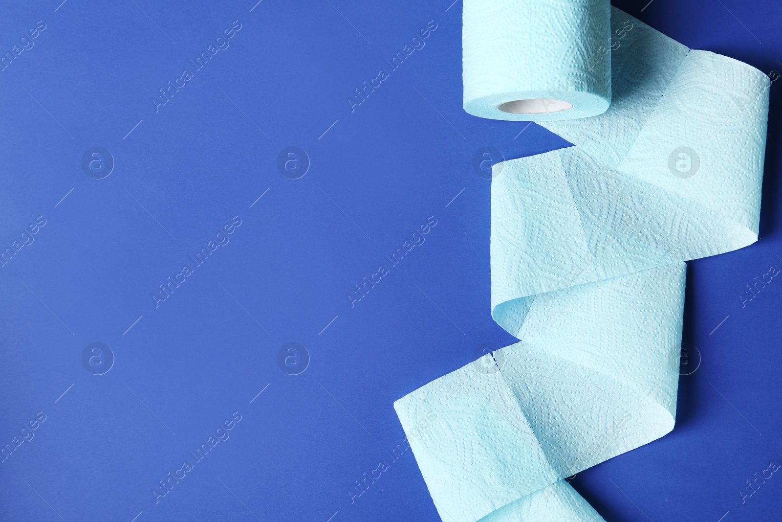 Photo of Toilet paper and space for text on color background, top view