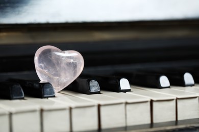 Beautiful heart shaped stone on piano keys, closeup. Space for text