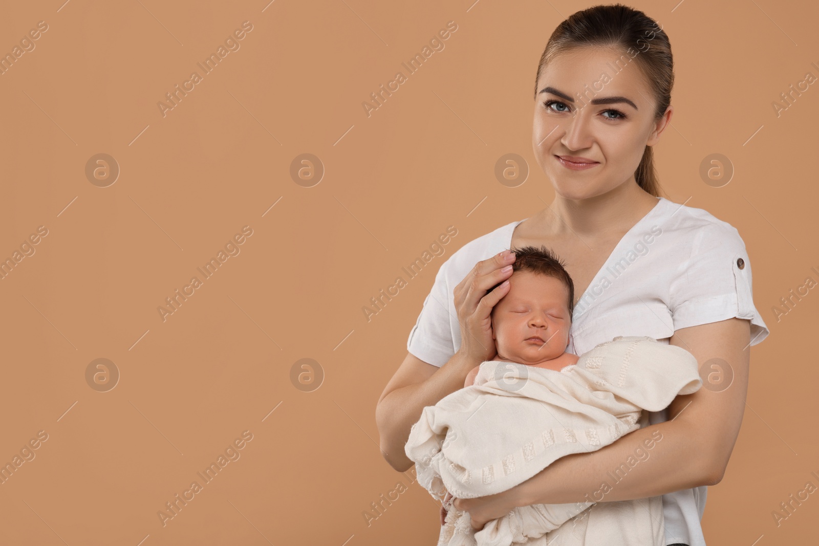 Photo of Mother with her cute newborn baby on beige background. Space for text