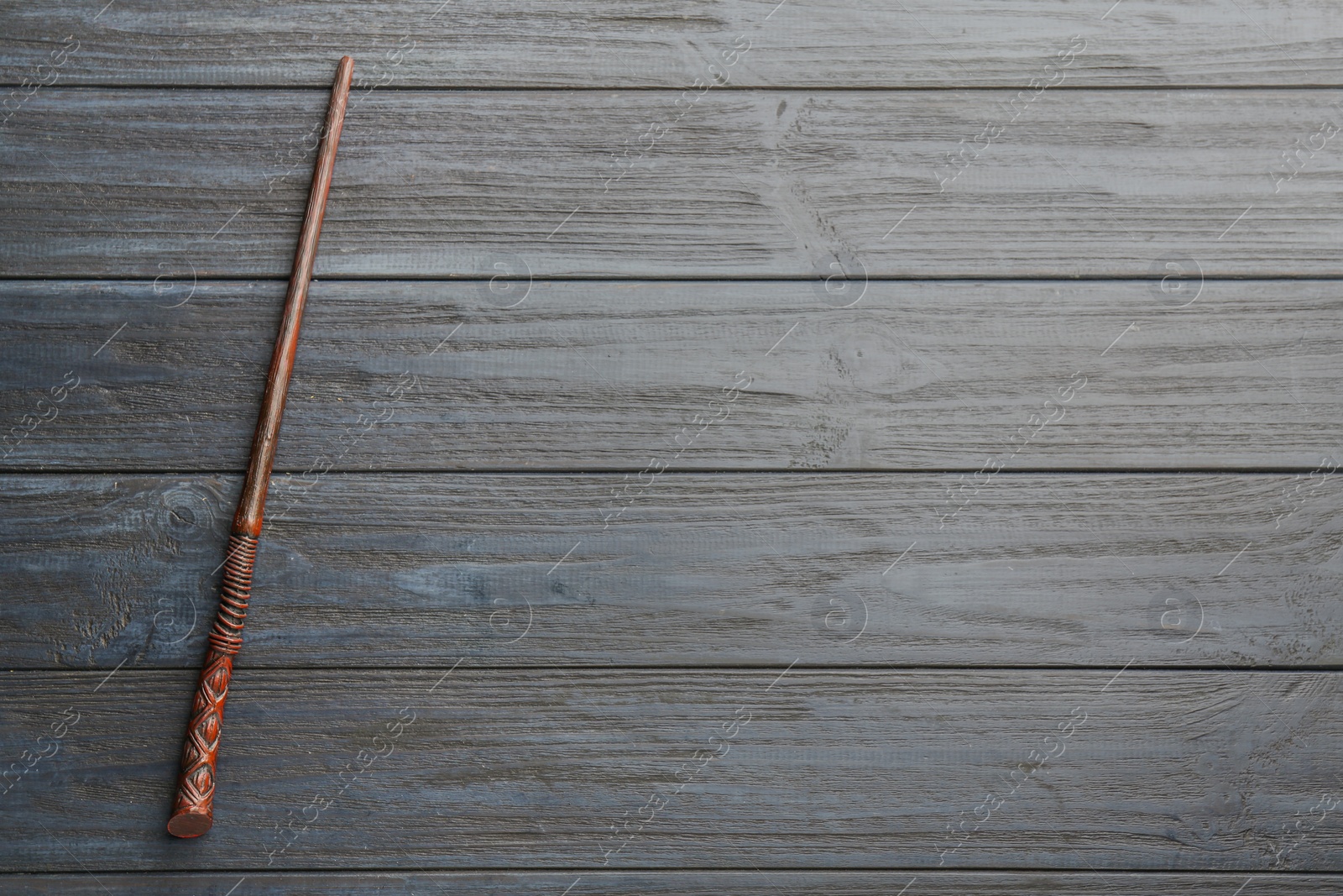 Photo of One old magic wand on grey wooden table, top view. Space for text