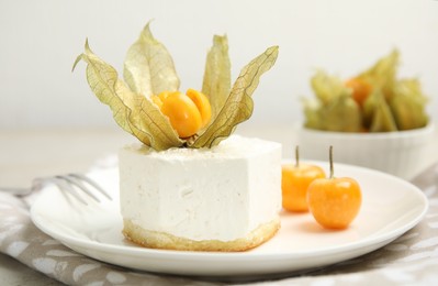 Photo of Delicious dessert decorated with physalis on grey table