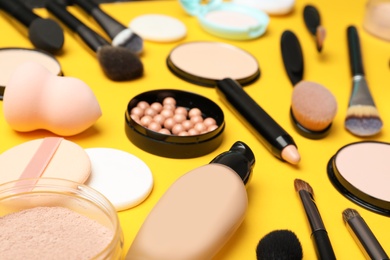 Photo of Composition with skin foundation, powder and beauty accessories on color background