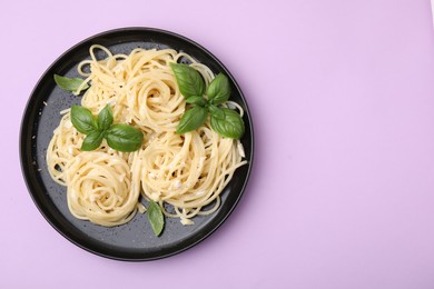 Photo of Delicious pasta with brie cheese and basil leaves on violet background, top view. Space for text