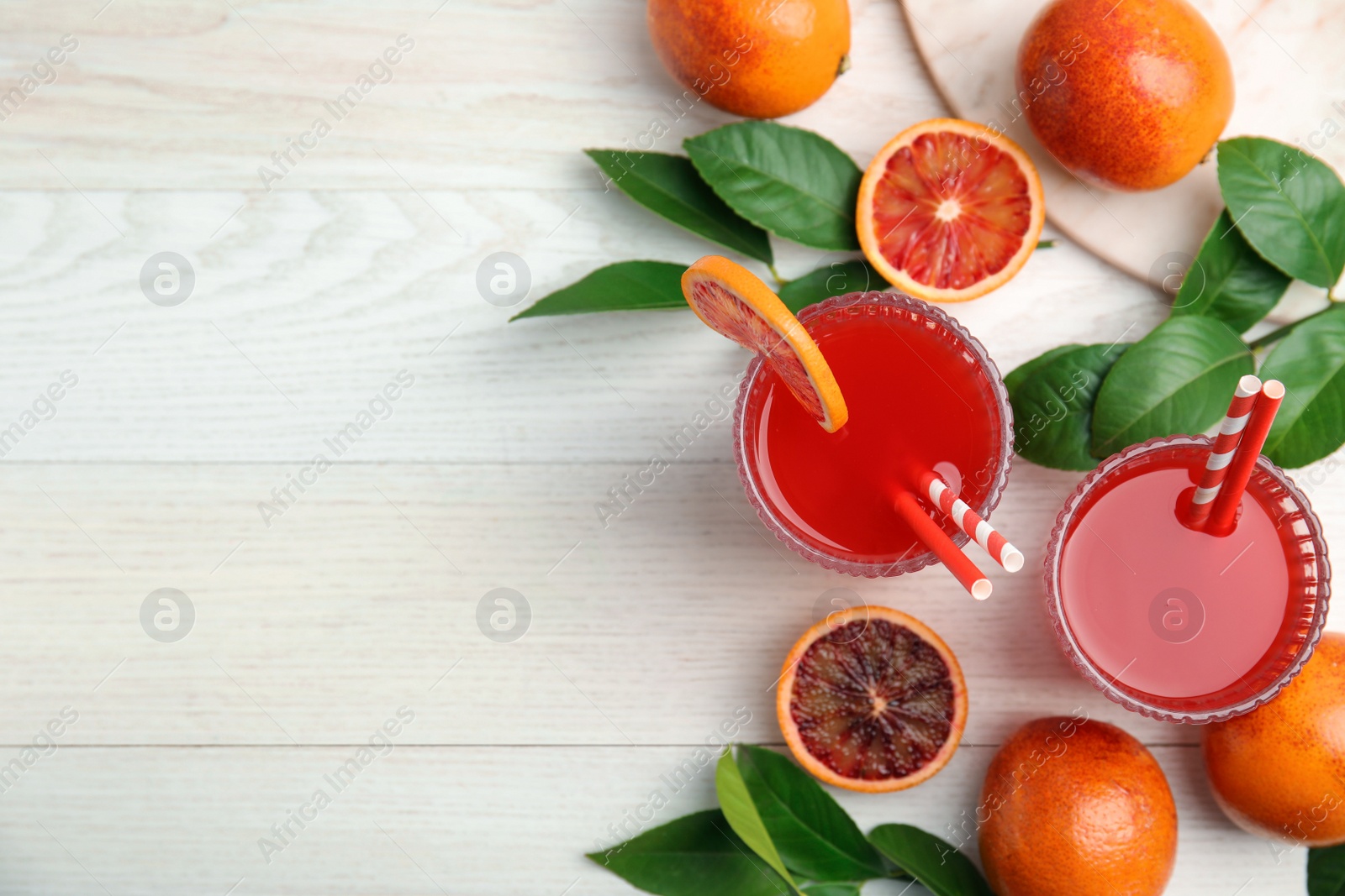 Photo of Tasty sicilian orange juice and fruits on white wooden table, flat lay. Space for text