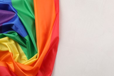 Photo of Rainbow LGBT flag on white background, top view. Space for text