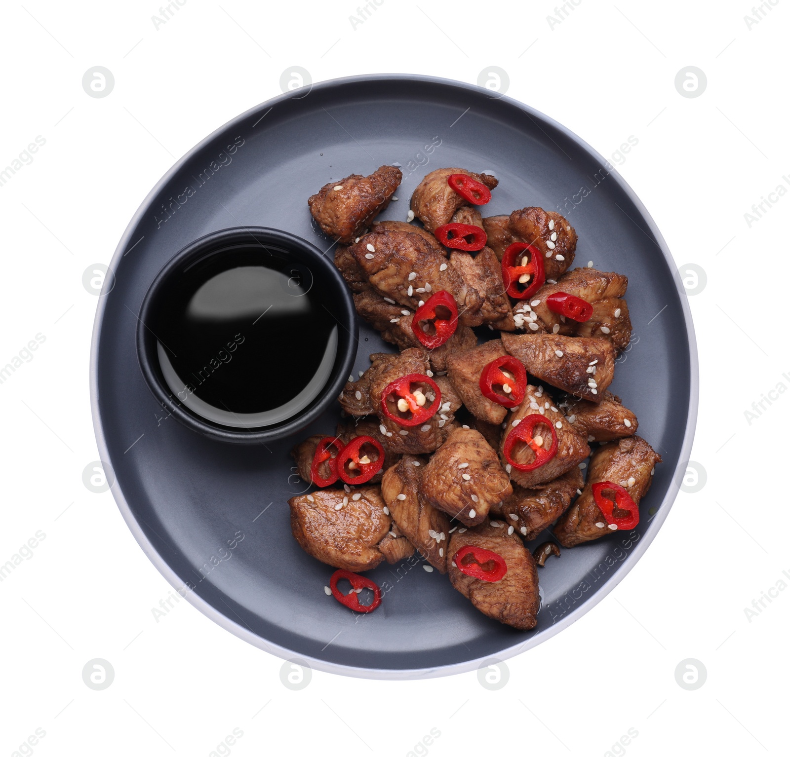 Photo of Plate with tasty soy sauce, roasted meat, sesame and chili pepper isolated on white, top view