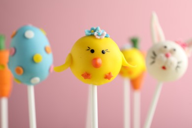 Delicious sweet cake pops on light pink background, closeup. Easter holiday