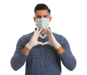 Man in protective face mask and medical gloves making heart with hands on white background