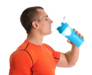 Photo of Athletic young man drinking protein shake on white background