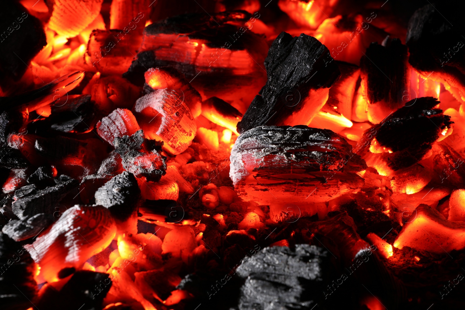 Photo of Pieces of hot smoldering coal as background, closeup