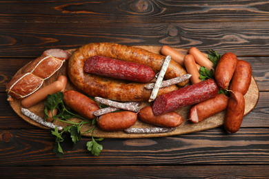 Photo of Different tasty sausages on wooden table, top view