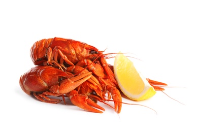Photo of Delicious red boiled crayfishes with lemon isolated on white