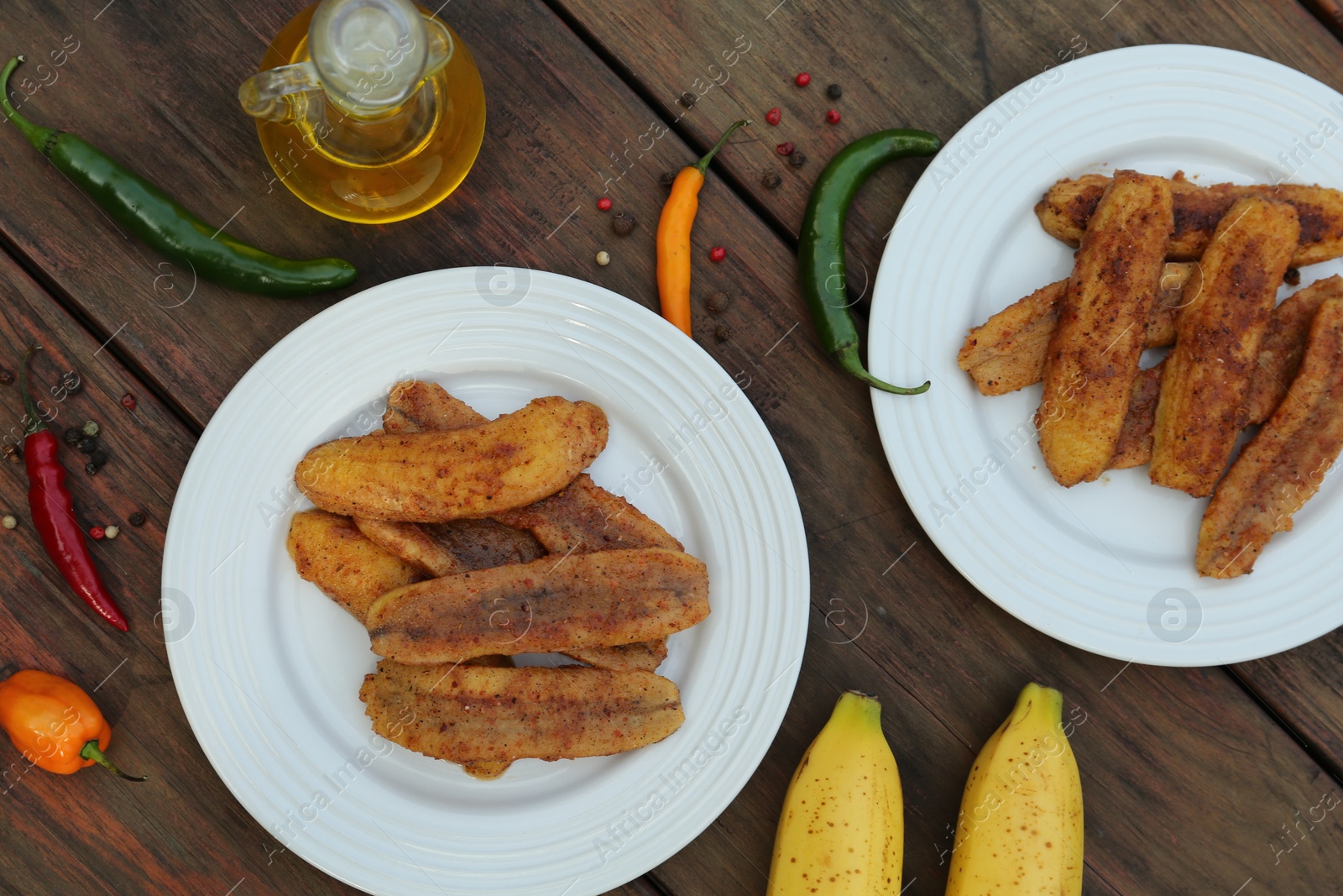 Photo of Delicious fried bananas, fresh fruits and different peppers on wooden table, flat lay